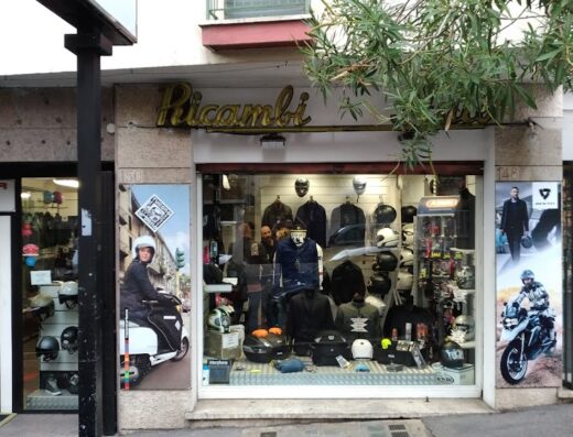 Negozio di ricambi moto Terenzio Moto, con vetrina che espone caschi, giacche e accessori per motociclisti. Presenti anche poster di scooter e moto da turismo.