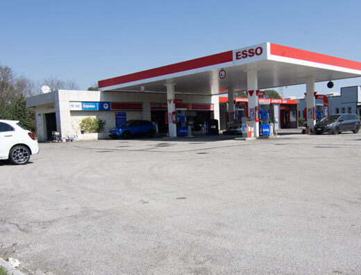 Stazione di servizio Esso su Viale Venezia con auto parcheggiate e pompe di benzina visibili, offre servizi di rifornimento e shop.