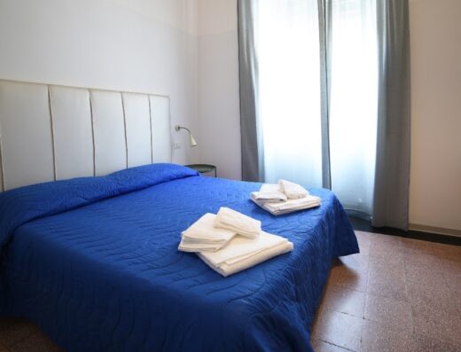 Camera matrimoniale accogliente al TIFEO Bed & Breakfast con letto blu, biancheria pulita e arredi confortevoli per un soggiorno rilassante.