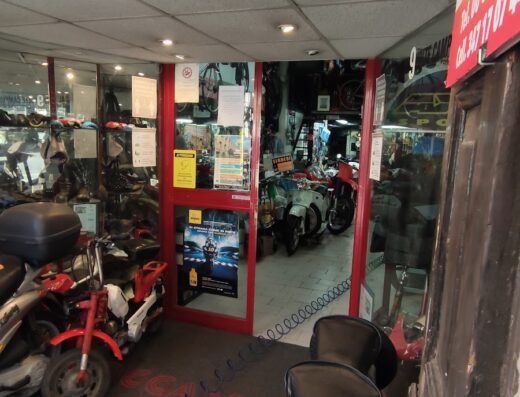 Ingresso di Toccamoto Roma, officina specializzata in riparazioni e restauri di moto e scooter d'epoca, con esposizione di modelli Vespa, Honda, Yamaha, Suzuki e Peugeot. Ampia scelta di accessori e ricambi per motocicli.