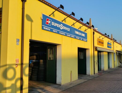Tommasin S. N. C. Centro SuperService building exterior, featuring tire service, motorcycle accessories, Dunlop and Goodyear signs.