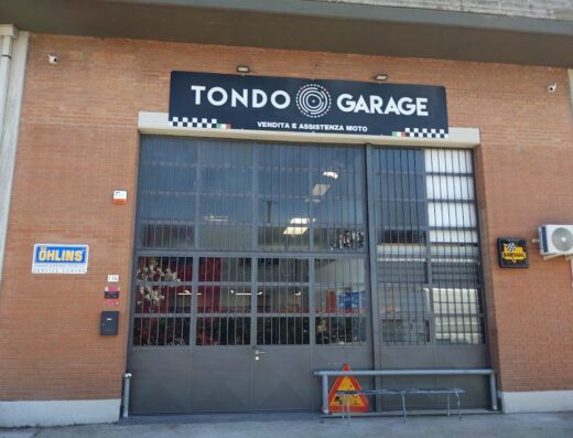 Tondo Garage exterior, a motorcycle service and sales center, with a sign for Ohlins Service Centre, offering moto assistance