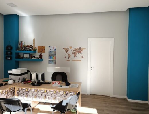 Ufficio di Top Of The Tour Di Cammarata D. & Amico D. s.n.c. con scrivania, computer, mensole con accessori e mappa del mondo. Agenzia viaggi e tour operator specializzato in viaggi in moto.