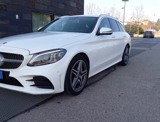 Auto bianca Mercedes-Benz Classe C Station Wagon parcheggiata a Bolzano Stazione, ideale per il noleggio auto a breve e lungo termine.