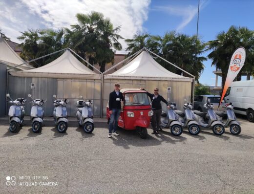 Tour in Vespa: fila di Vespa e un Apecar rossa con due persone davanti, pronte per un tour su due ruote.