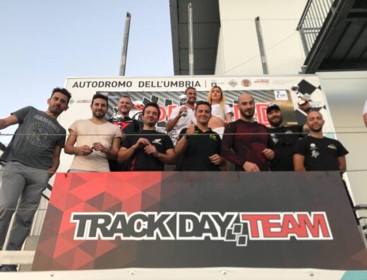 Team Track Day celebra la vittoria delle prove libere moto in pista all'Autodromo dell'Umbria, con piloti e membri del team sul podio.
