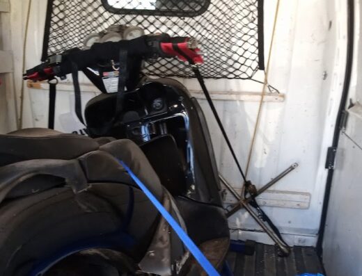 Trasporto scooter e moto in Molise: dettaglio di una moto nera fissata all'interno di un furgone bianco per un trasporto sicuro.