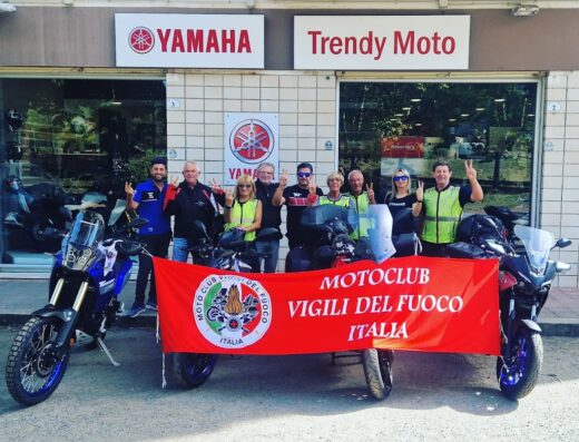 Gruppo di motociclisti del Motoclub Vigili del Fuoco Italia davanti a Trendy Moto Yamaha S.R.L. con moto Yamaha, accessori e abbigliamento da moto.