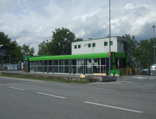 Edificio moderno con vetrate e dettagli verdi, Trevisomareservizi Srl, design architettonico funzionale e contemporaneo.