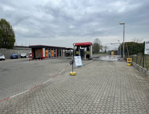 TURIWASH Autolavaggio: Vista esterna dell'autolavaggio con pista self-service attrezzata per moto e auto, situato in una zona di servizio.
