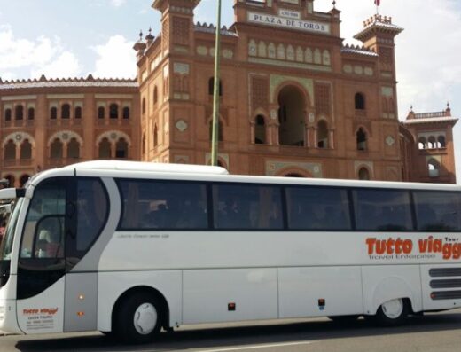 Autobus Tutto Viaggi Tour parcheggiato di fronte alla Plaza de Toros di Siviglia, che offre servizi di trasporto turistico e tour guidati.