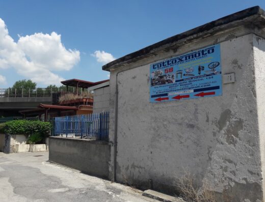 Insegna di Tutto X Moto, negozio di ricambi moto e auto usati a Napoli, con indicazioni stradali e contatti.