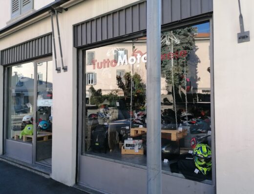 Vetrine del negozio TuttoMoto Varese, specializzato in accessori e abbigliamento per motociclisti, con caschi, borse e altro equipaggiamento visibile.