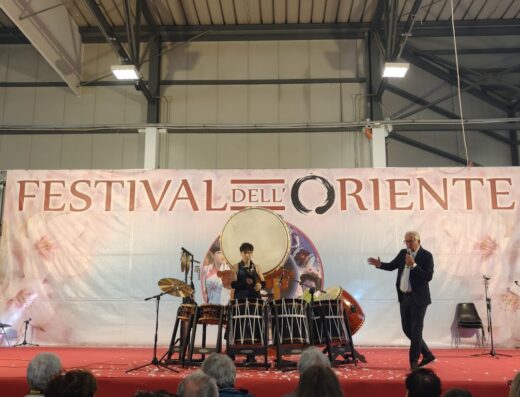Esibizione al Festival dell'Oriente presso Umbriafiere S.p.A. con musicisti che suonano tamburi tradizionali giapponesi (Taiko) e un presentatore sul palco.