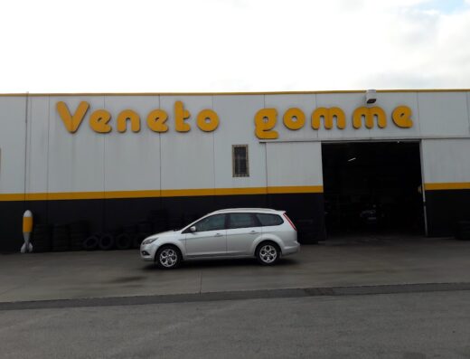 Veneto Gomme: immagine di un'auto parcheggiata di fronte all'edificio del negozio di pneumatici. Servizi professionali per la cura della tua auto.