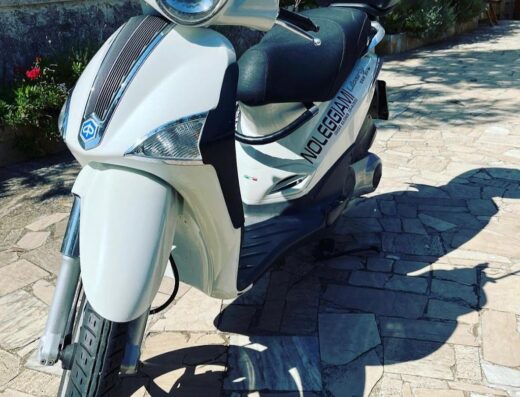 Noleggio scooter Verygood: primo piano di uno scooter bianco parcheggiato all'aperto, ideale per esplorare la città e godersi la libertà su due ruote.