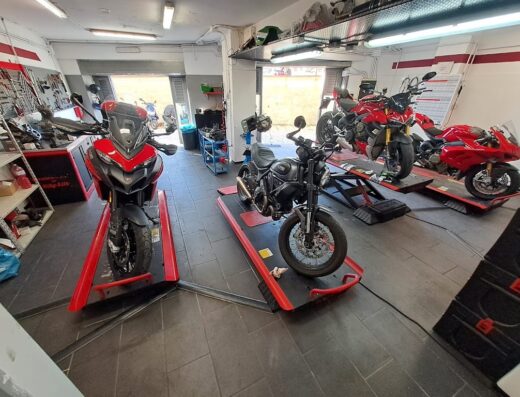Officina Vicinanza Moto Ducati Service a Salerno con moto Ducati rosse su piattaforme di sollevamento, manutenzione e riparazione.