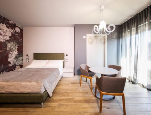 Camera di lusso al Vicolo Malavolta 7, con letto matrimoniale, tavolo rotondo e sedie di design. Arredamento moderno e accogliente per un soggiorno indimenticabile.