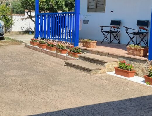 Villa Rosetta Casa Vacanze a Palmi: Veranda esterna con sedie, scala con vasi di fiori e pavimentazione decorata, ideale per un soggiorno rilassante.