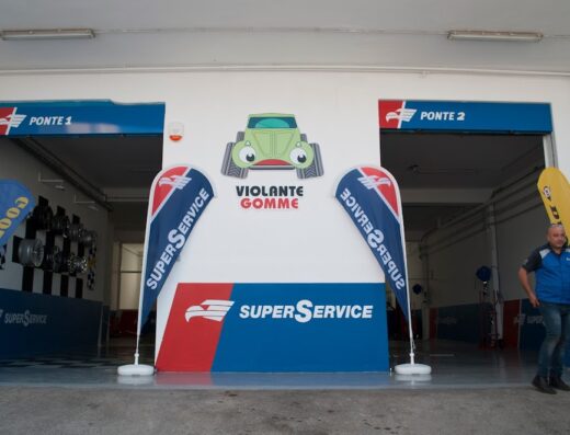 Violante Gomme Centro SuperService entrance featuring 'Ponte 1' and 'Ponte 2' bays, SuperService branding, and a man in work attire.