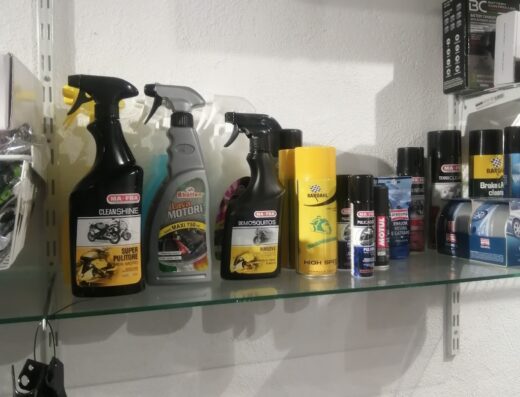 Scaffale con prodotti per la pulizia e la manutenzione della moto, inclusi detergenti Ma-Fra CleanShine, Rhütter Motori, Bardahl High Speed, e altri accessori per motociclisti.