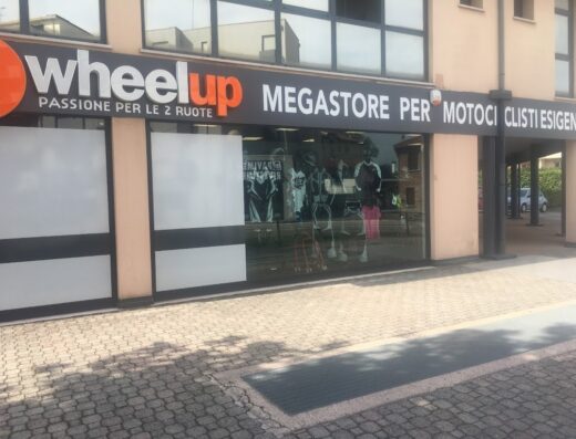 Wheelup Megastore per motociclisti esigenti, negozio di accessori e abbigliamento moto. Ampia vetrina con caschi, giacche e protezioni per motociclisti.