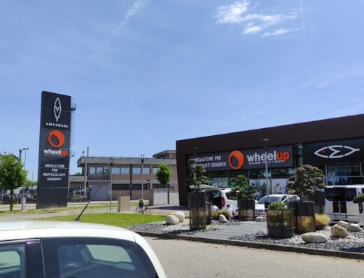 Esterno del negozio Wheelup, megastore per motociclisti esigenti, con insegna verticale e orizzontale ben visibili. Accessori e abbigliamento moto delle migliori marche.
