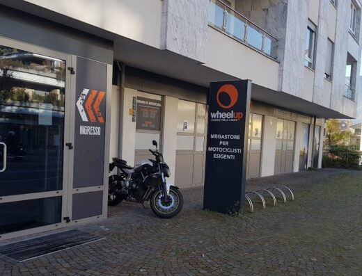 Wheelup, megastore per motociclisti esigenti: una moto parcheggiata di fronte all'ingresso del negozio di accessori e abbigliamento moto.