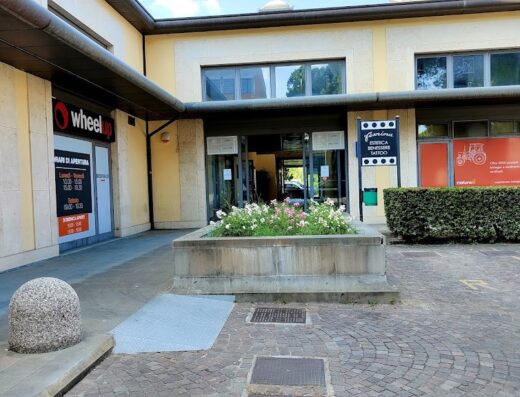 Ingresso del negozio Wheelup, specializzato in accessori e abbigliamento per moto e motociclisti, con insegna ben visibile e orari di apertura esposti.