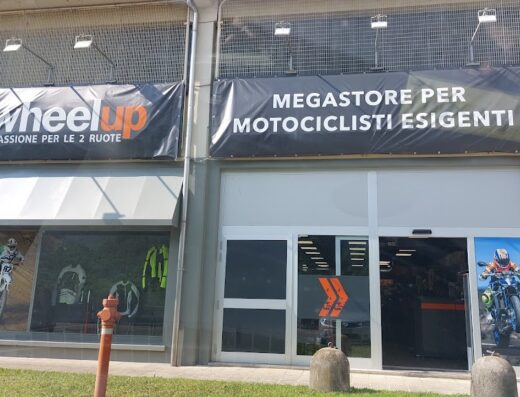 Negozio Wheelup: megastore per motociclisti esigenti. Vetrina con moto da cross, abbigliamento tecnico e accessori per motociclismo e viaggi in moto.