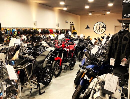 Esposizione di moto nuove e caschi da XTRAMOTO: modelli adventure, BMW, e scooter Vespa in vendita nel negozio.