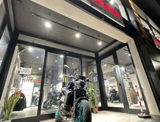 Moto Yamaha in esposizione presso il concessionario Rossi Moto a Roma, con pneumatici turchesi e insegna luminosa Yamaha.