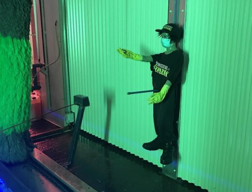 Ragazzo che lavora all'autolavaggio moto Yellow Wash S.r.l., indossa guanti e mascherina protettiva durante la pulizia.