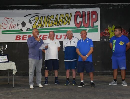 Uomini sul palco durante la premiazione della Zangardi Cup, con trofei in esposizione e la mascotte di Mickey Mouse