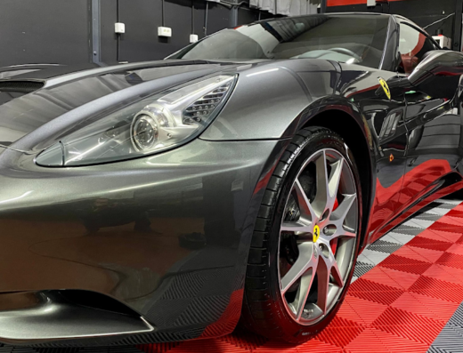 Dettaglio di una Ferrari grigia lucidata presso Zena Car Detailing, che mostra la brillantezza della vernice e i dettagli delle ruote.