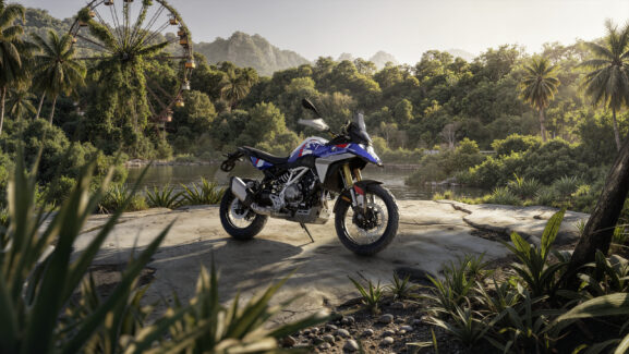 La nuova BMW F 450 GS parcheggiata su una spianata rocciosa circondata da una vegetazione tropicale con una ruota panoramica sullo sfondo